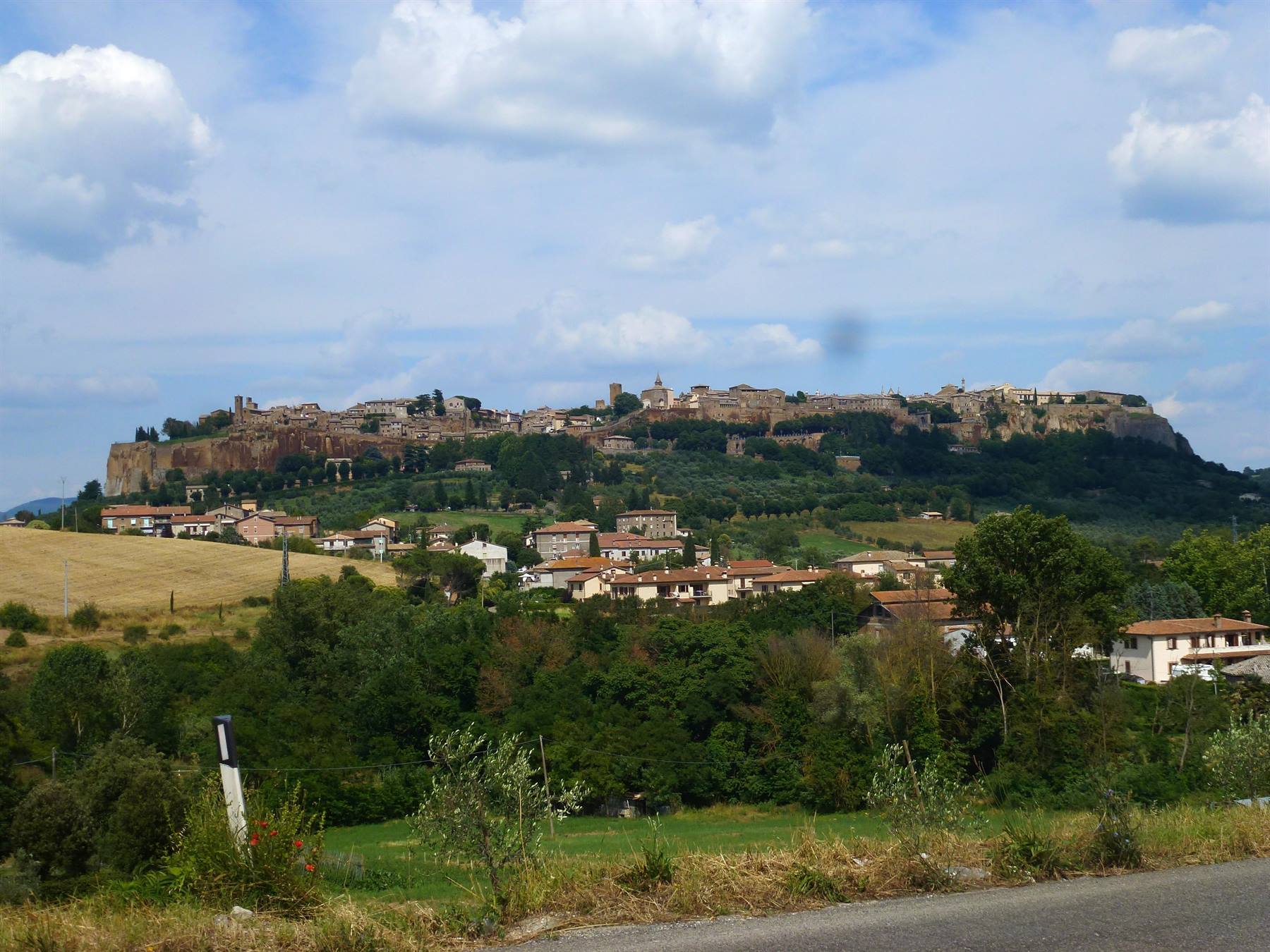 Orvieto: case in mattoni sotto il borgo arroccato sulla rupe di tufo, tra campi e ulivi