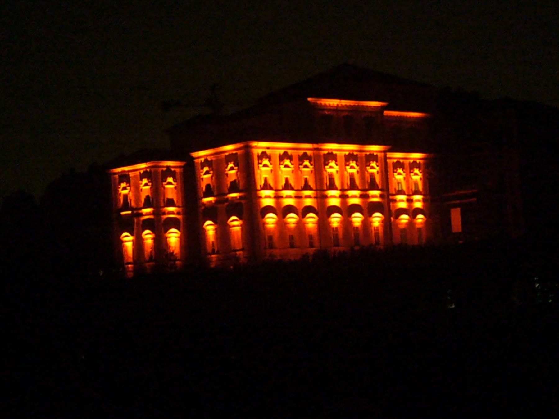 Palazzo storico illuminato di luce arancione nella notte scura