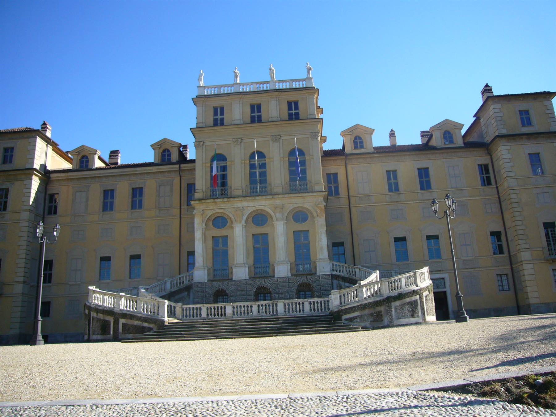 Palazzina di caccia di Stupinigi, facciata gialla con scalinata bianca e bandiera italiana