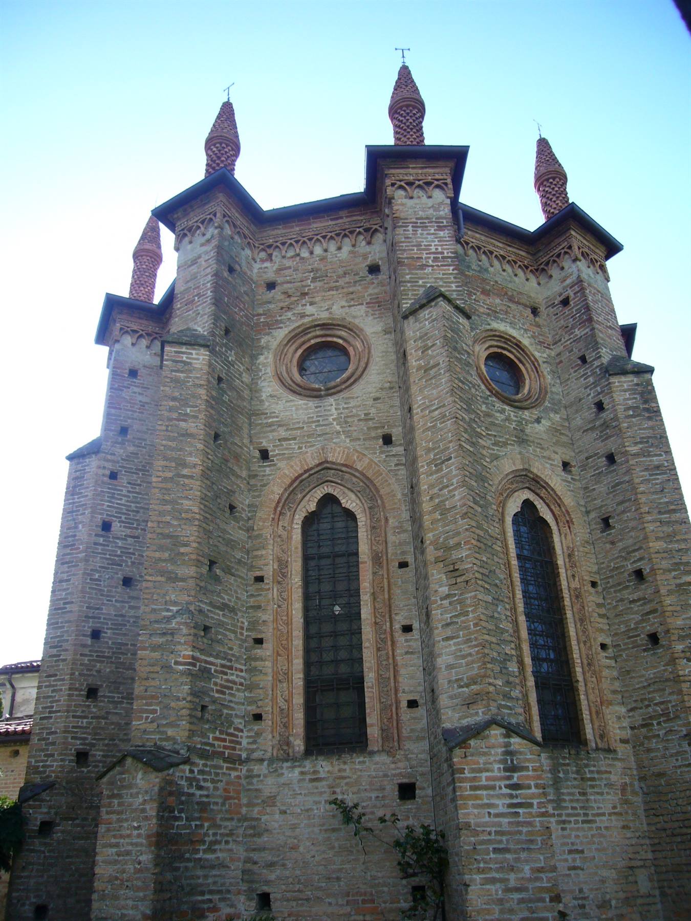 Chiesa gotica in mattoni con guglie, monofore e rosatti, luce diurna