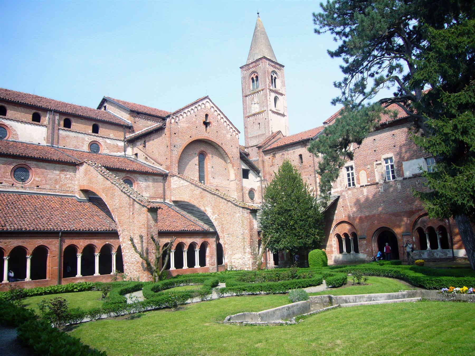 Chiostro in cotto e campanile romanico della basilica di Aquileia, giardino verde