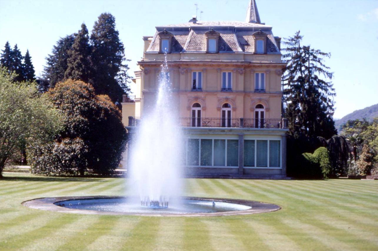 Fontana getta acqua alta davanti a villa storica con giardino verde