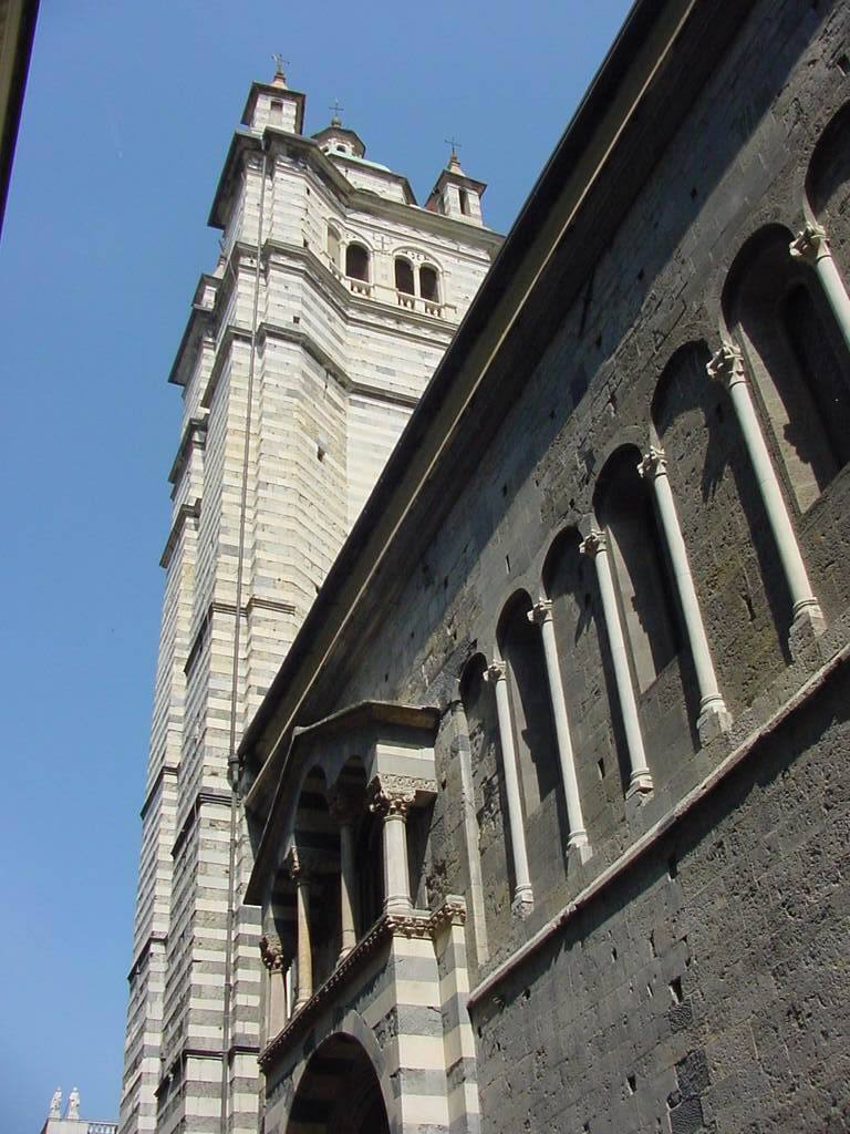 Campanile a fasce bianche e grigie e fianco romanico del duomo di Genova