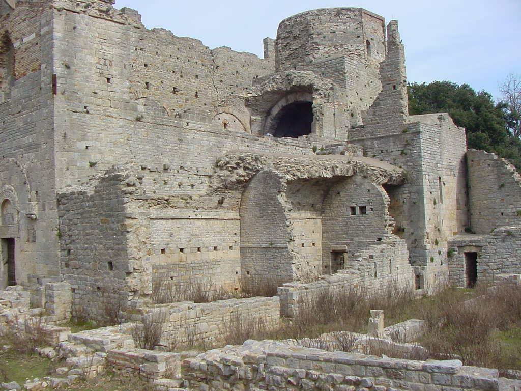 Ruderi di un'abbazia medievale in pietra, archi e abside incompiuti