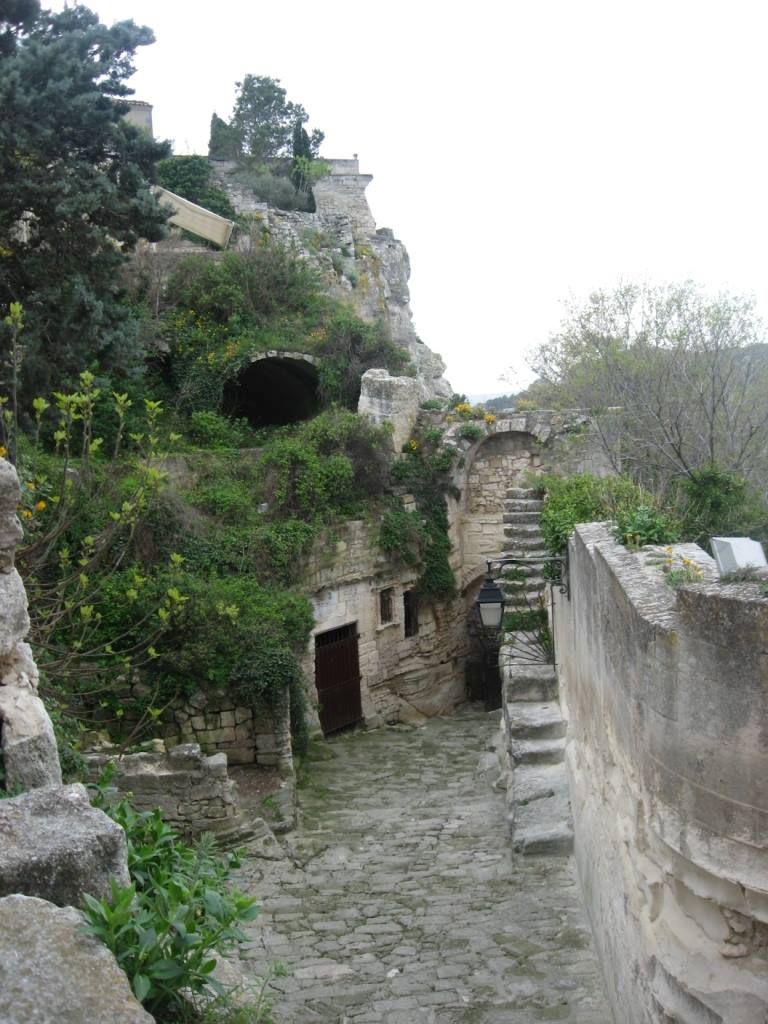 Rovine medievali in pietra con scala e portale, verde che avvolge il borgo