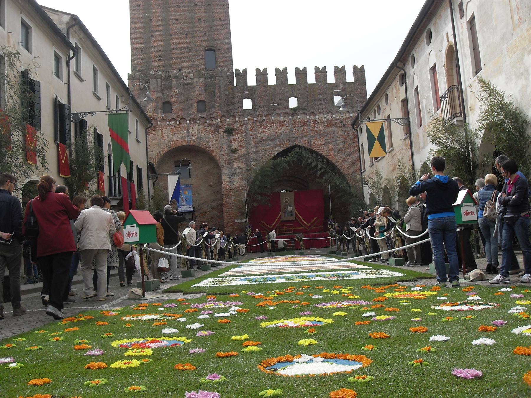 Infiorata di fiori colorati davanti al castello di Marostica, visitatori ammirano