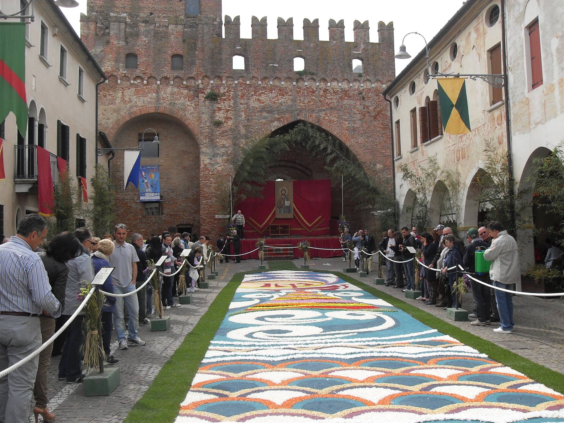 Infiorata di fiori colorati davanti al castello, folla di visitatori a Montagnana