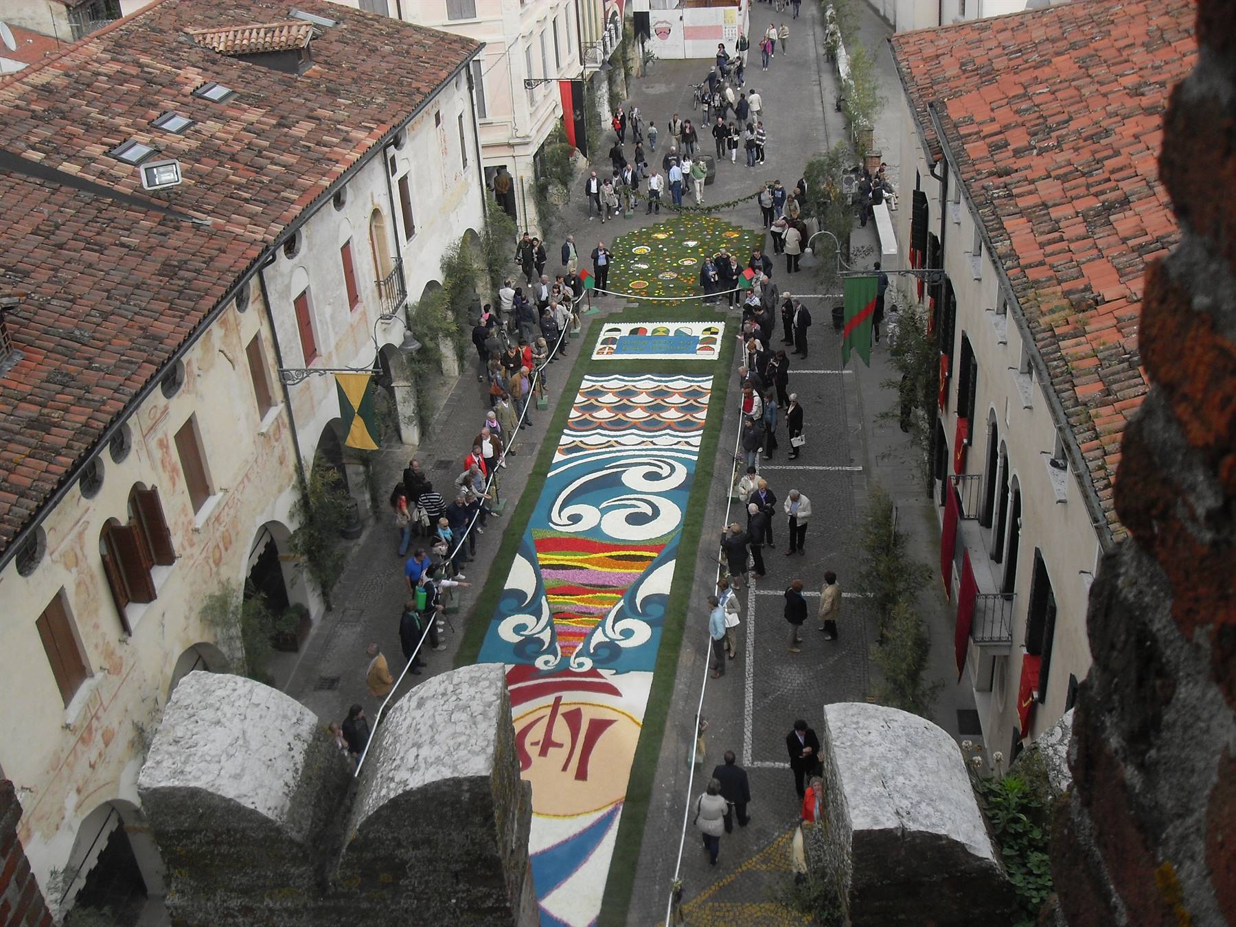 Infiorata con tappeto dipinto tra le case di Marostica, vista dai merli del castello