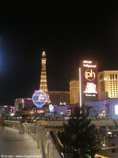 Las Vegas di notte: la torre Eiffel illuminata del Paris e il globo di Planet Hollywood