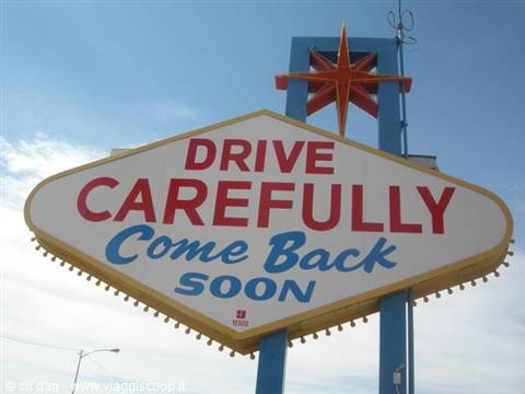 Retro dell'insegna di Las Vegas: 'Drive Carefully, Come Back Soon', stella dorata sopra