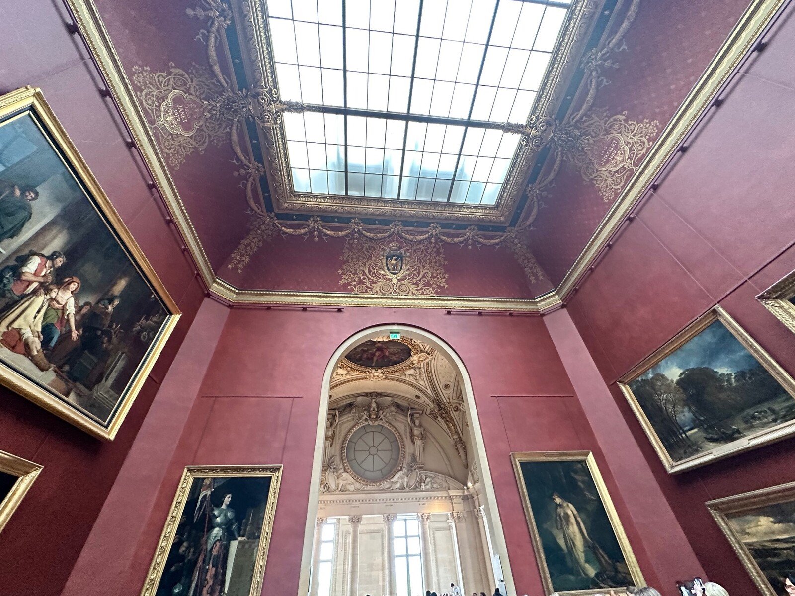 Sala del Louvre: la luce del soffitto illumina capolavori senza tempo.