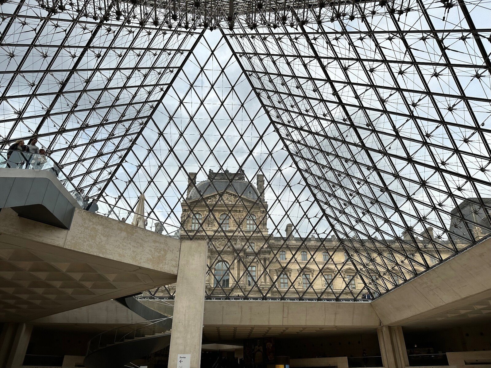 Sotto la piramide vetrata del Louvre, il tempo sembra sospeso.