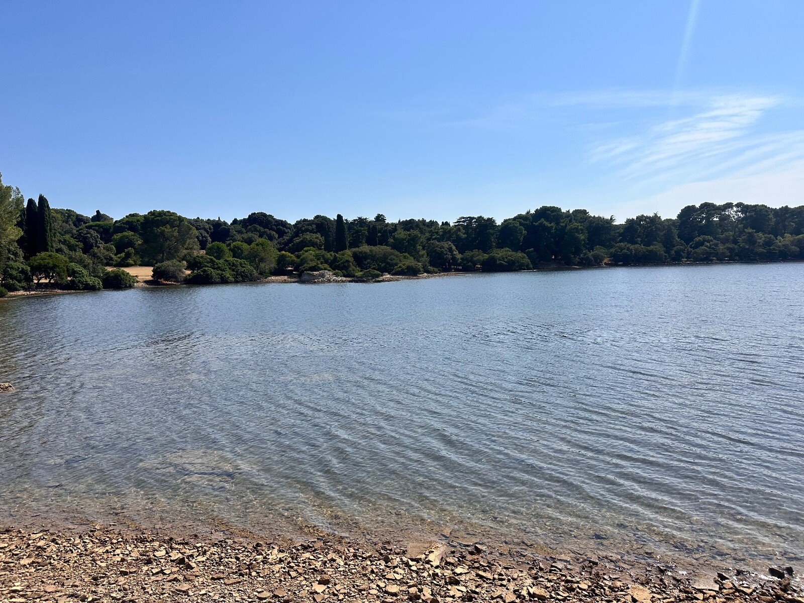 Acque tranquille e cielo azzurro: una pausa di pace in riva al lago.
