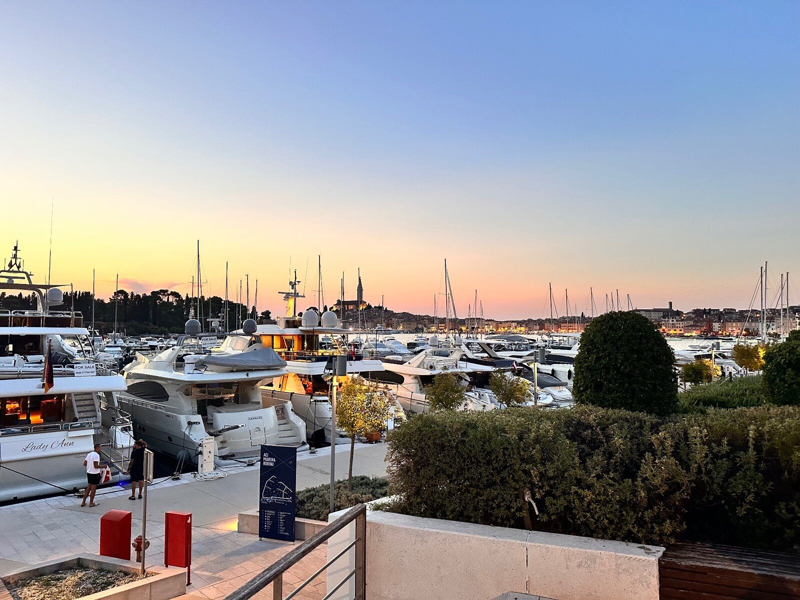 Tramonto sul porto di Rovigno, tra yacht e luci che si accendono.