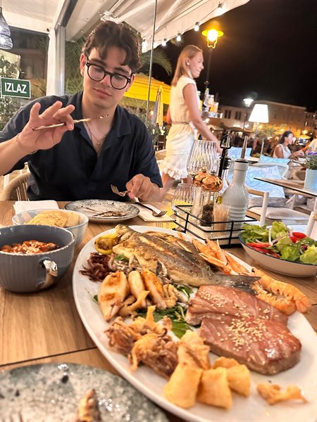 Cena di pesce sotto le luci della sera, un piatto gigante da condividere