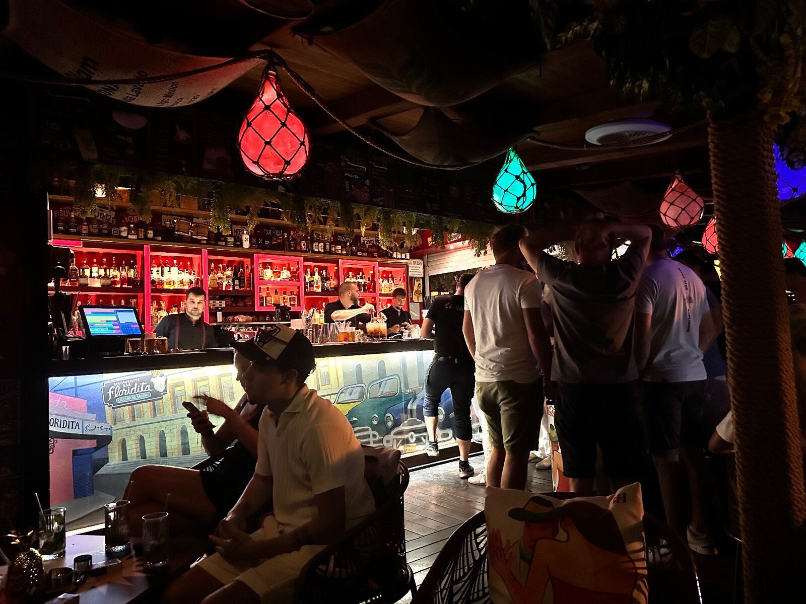 Sera al Floridita: luci colorate, cocktail e risate al bar.