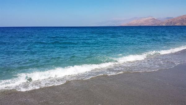 Il mare che accarezza la riva, momente di pura serenità greca.
