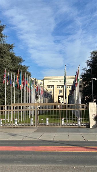 Davanti al Palais des Nations di Ginevra, tra bandiere al vento e cielo azzurro.