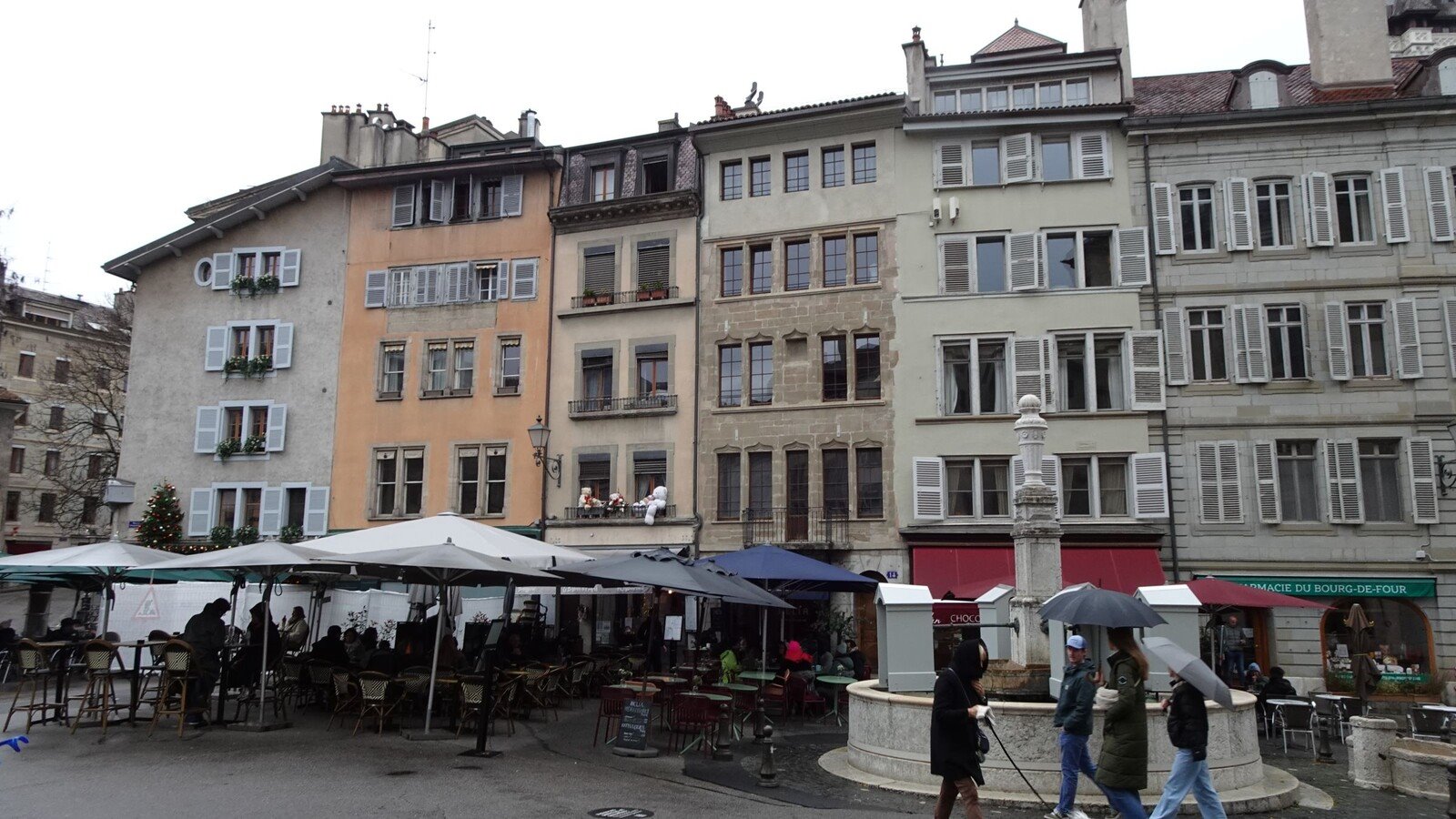Piazza Bourg-de-Four a Ginevra, caffè sotto gli ombrelloni nonostante la pioggia.