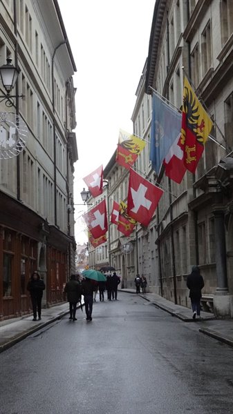 Passeggiata sotto la pioggia tra le bandiere svizzere a Ginevra.