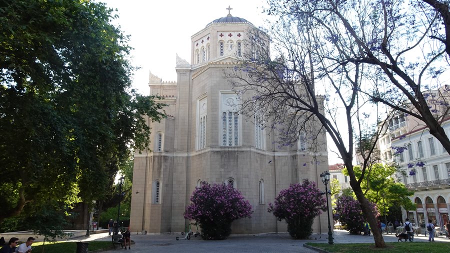 Pomeriggio dorato ad Atene: la cattedrale custodisce fiori viola e ricordi.