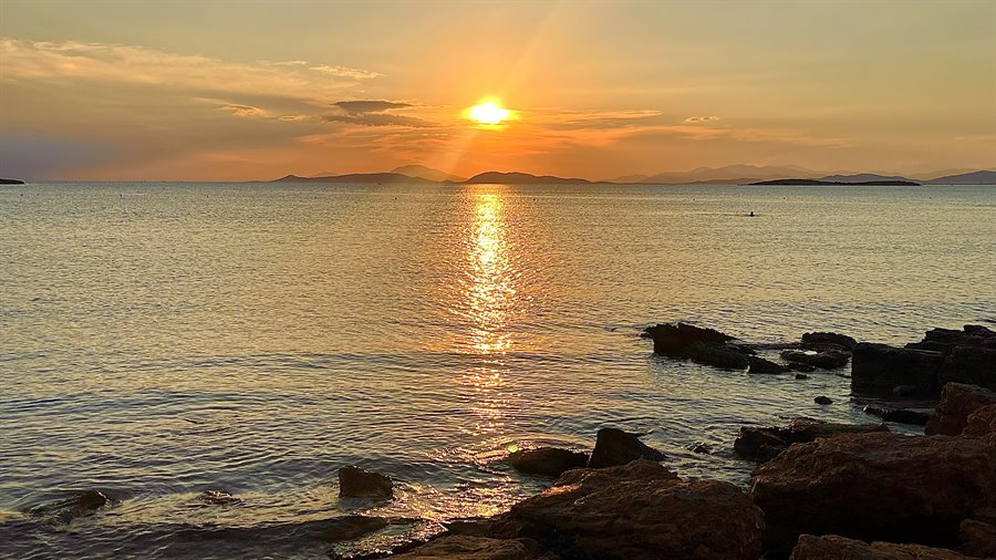 Il sole tramonta sul mare: un ricordo d'oro da incollare nel diario.
