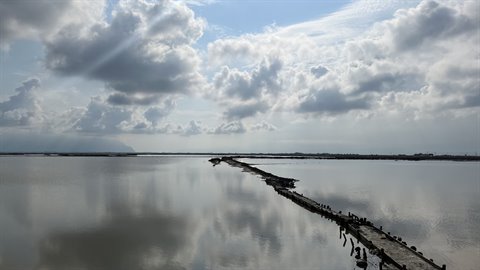 Un lungomare dimenticato dal tempo, riflesso tra cielo e silenzio.