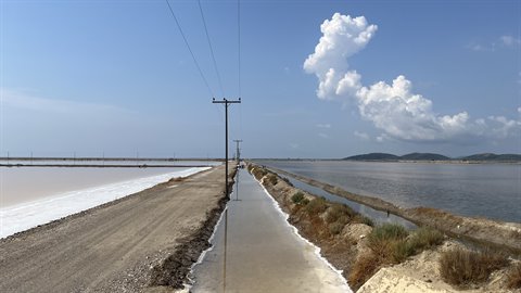 Cammino tra le saline, il cielo si specchia nell'acqua salata.