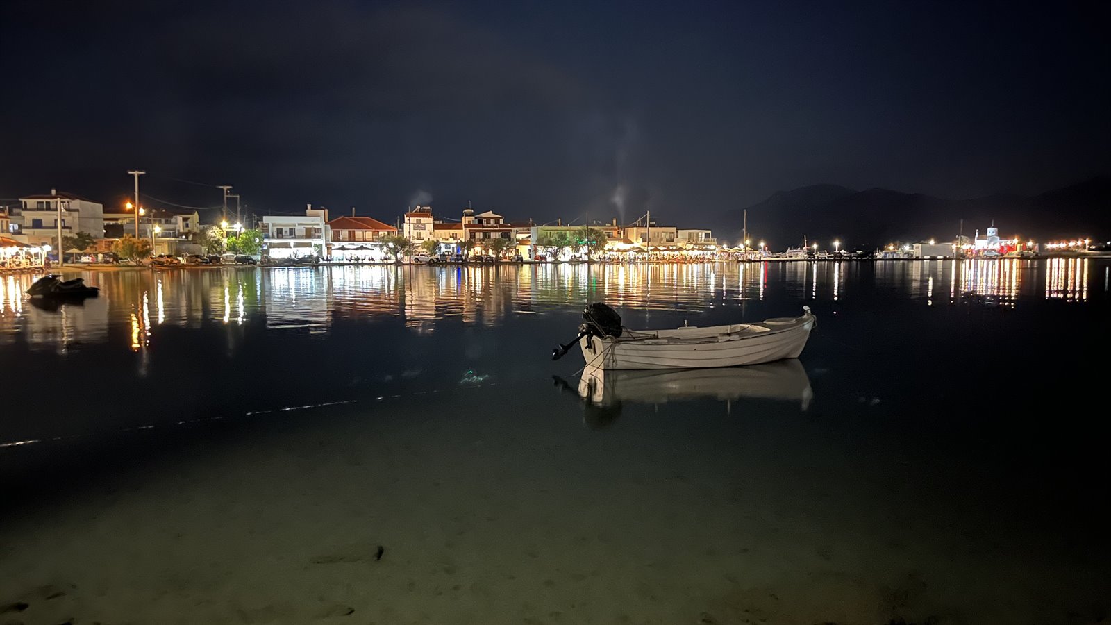 La barca dorme, le luci danzano sull'acqua. Notte magica.