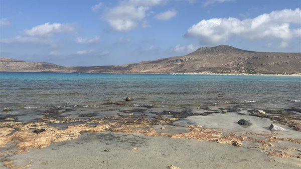 Acque turchesi e montagne silenziose: il mare che ti ruba il cuore.