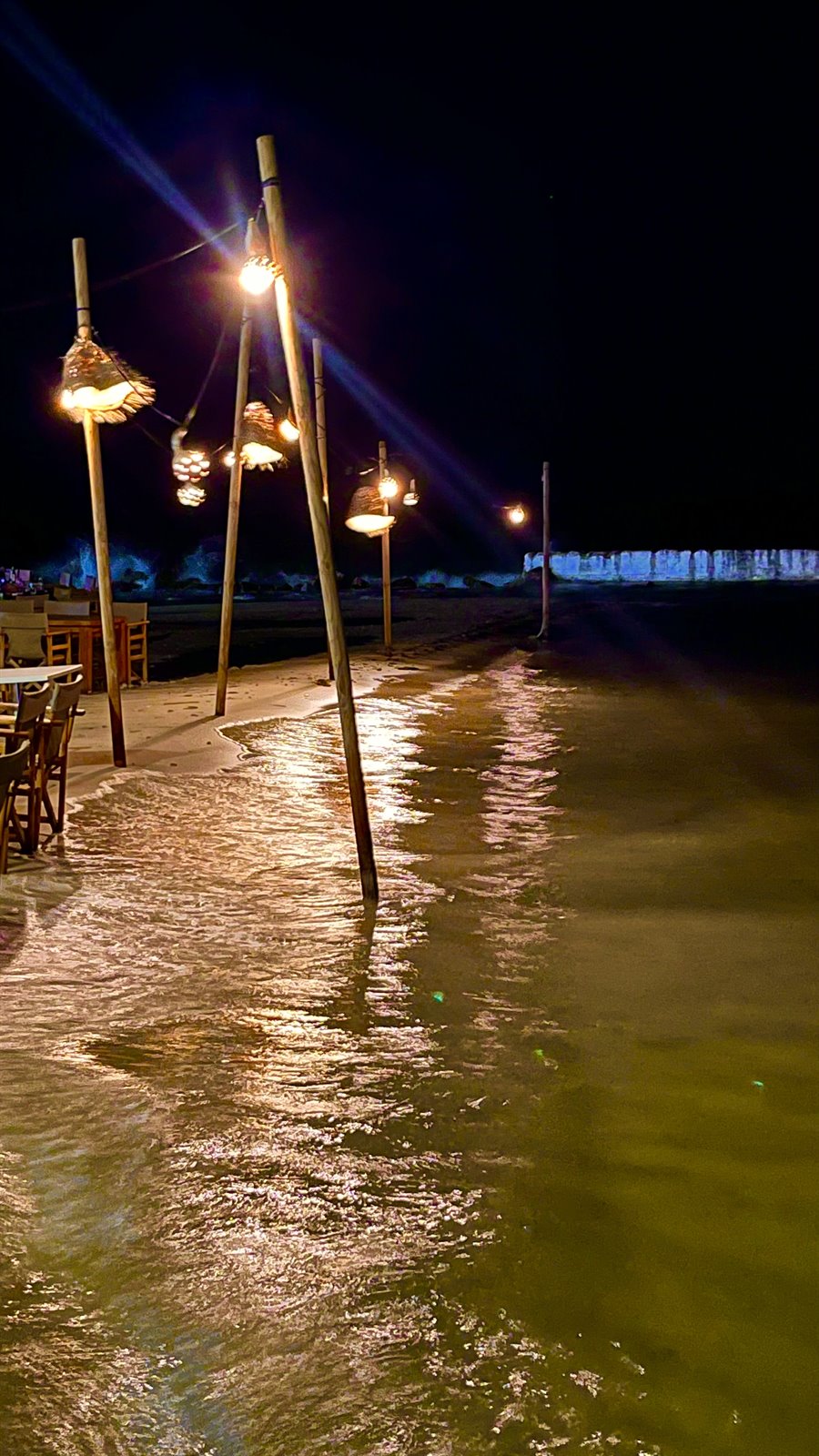 Lampade sul mare, luci che danzano: serata magica sulla spiaggia.