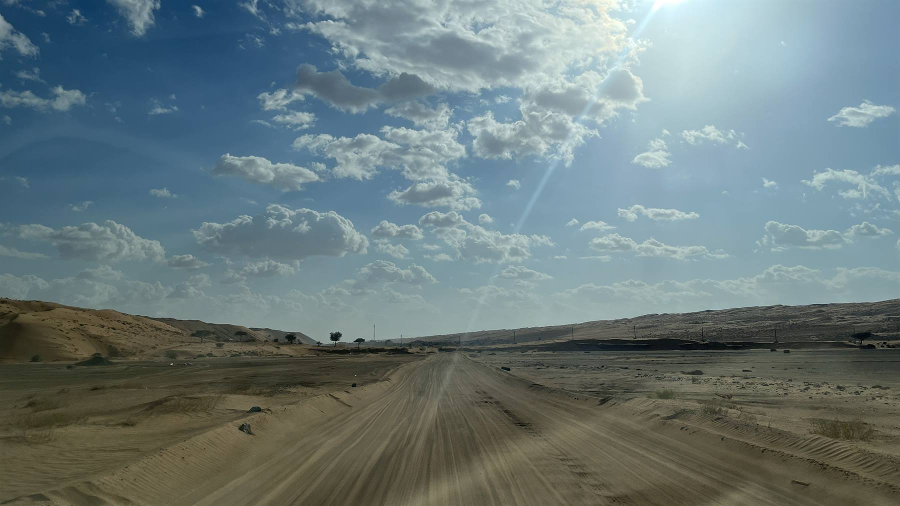 Il sole ci accompagna su questa strada di sabbia infinita.