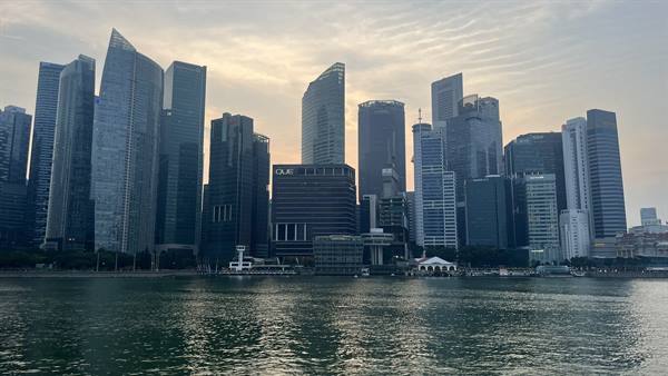 Grattacieli di Singapore al tramonto, il cielo si tinge d'oro.
