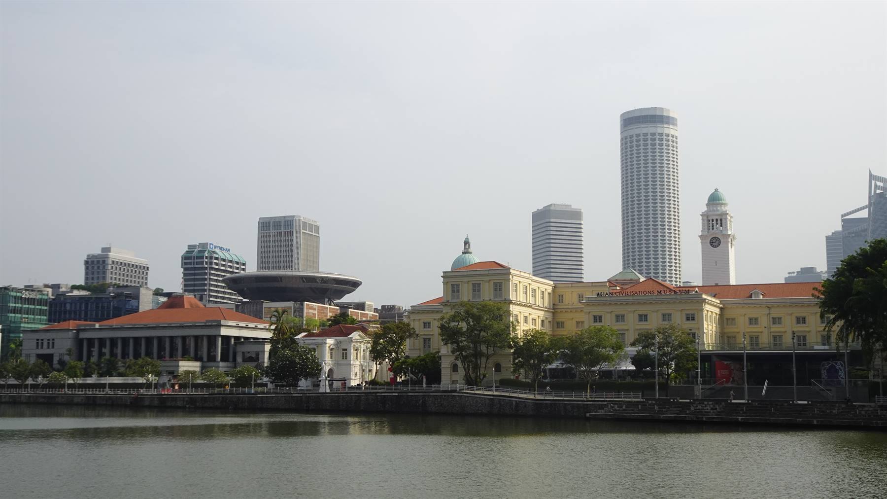 Sotto un cielo velato, Singapore si specchia tranquilla nelle acque del fiume.