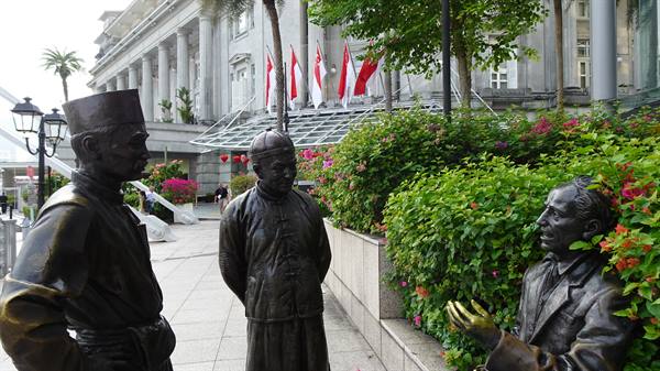 Storie di bronzo tra i fiori di Singapore, un incontro sospeso nel tempo.