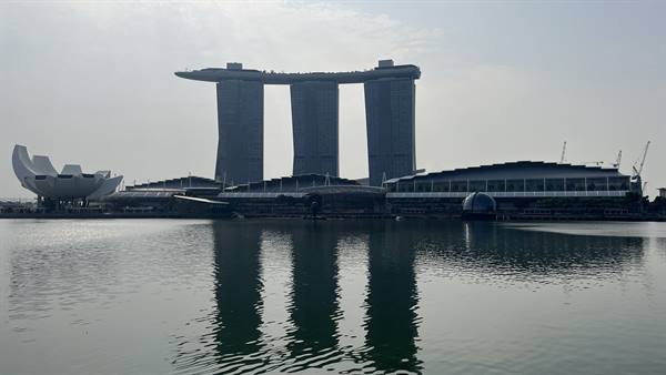 Singapore ci accoglie: il Marina Bay Sands si specchia nell'acqua quieta.