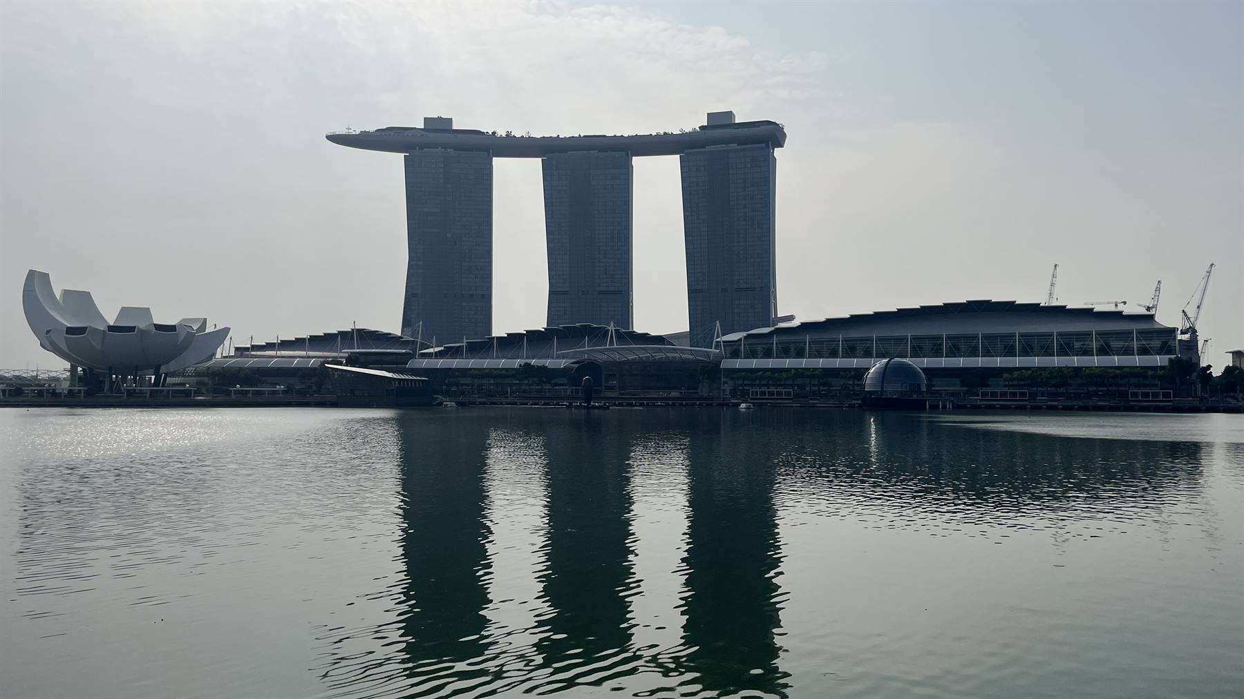 Singapore ci accoglie: il Marina Bay Sands si specchia nell'acqua quieta.