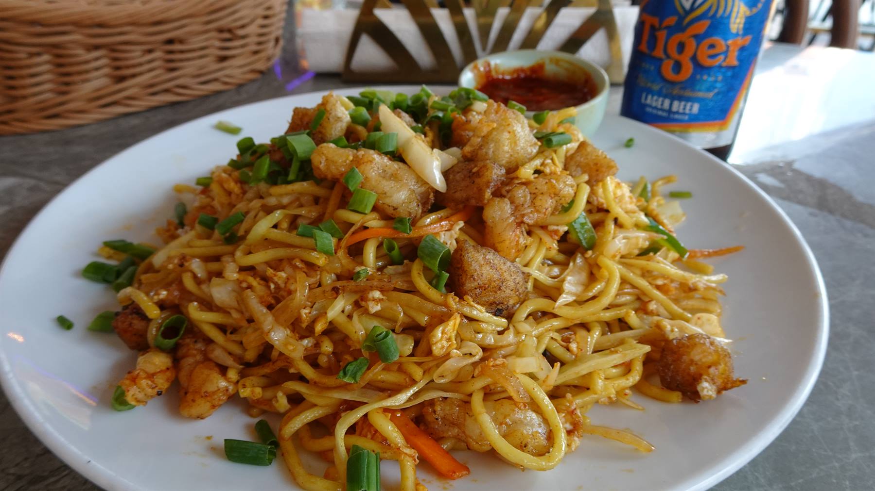 Noodles saltati in padella e una Tiger fresca: il perfetto pranzo di viaggio.