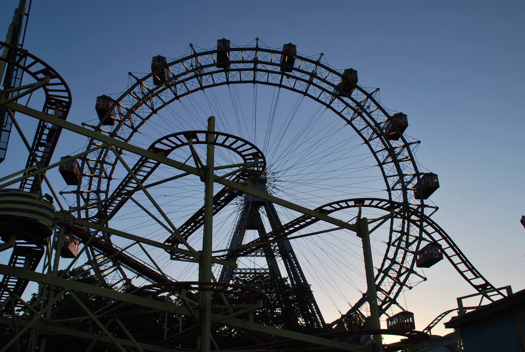 La ruota Riesenrad del Prater di Vienna in controluce tra le montagne russe