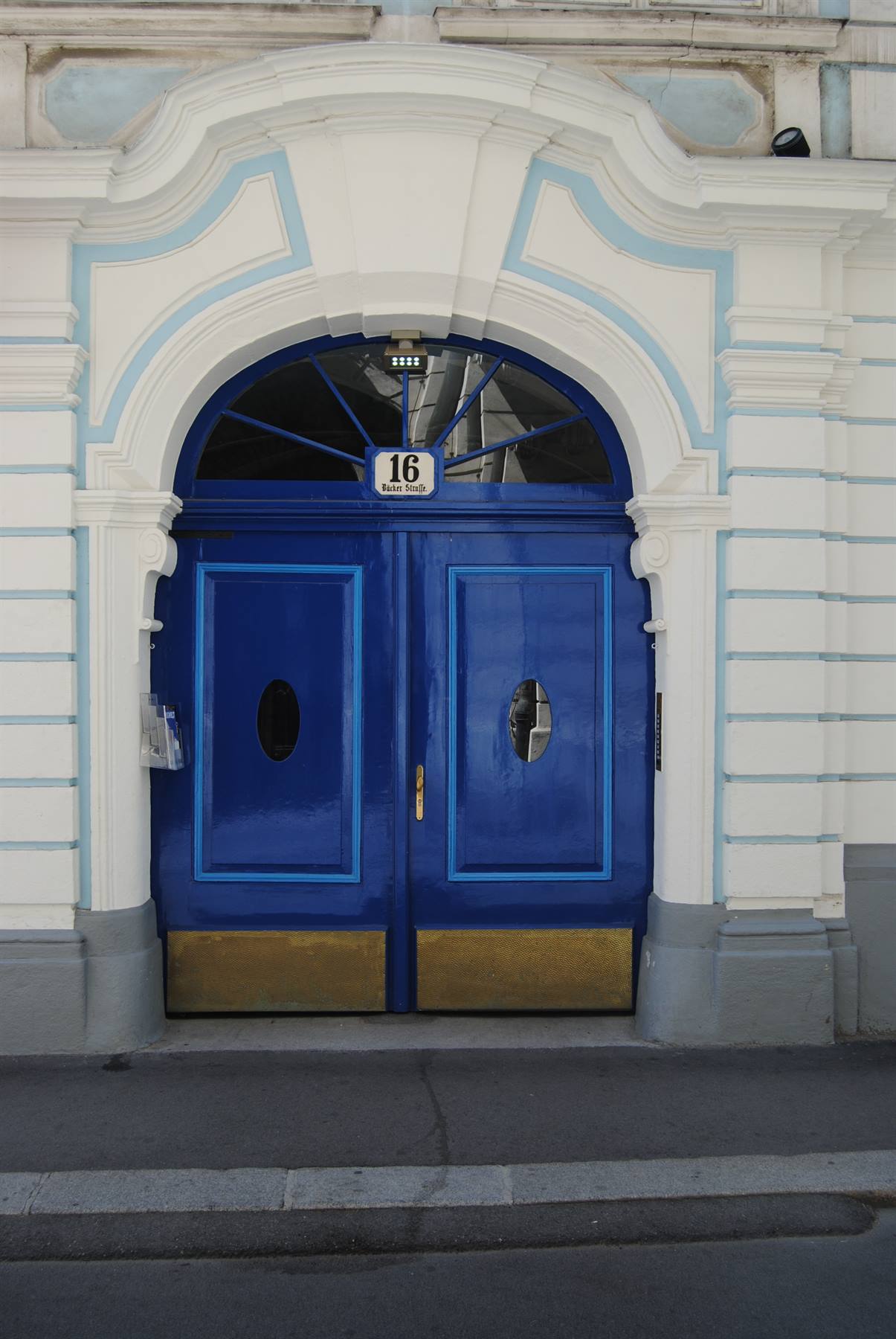 Porta doppia blu con numero 16, cornice barocca bianca e azzurra