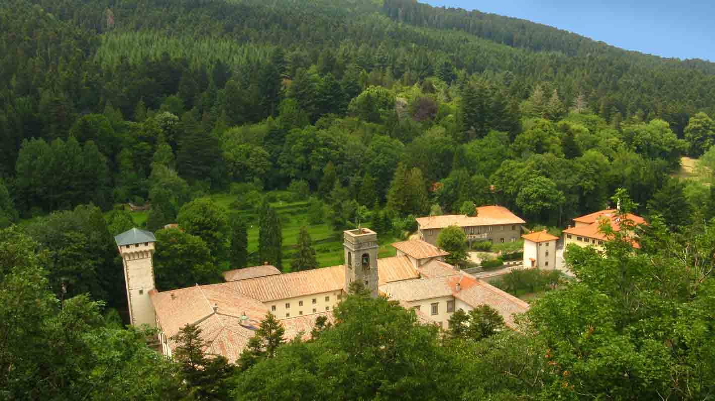Monastero con campanile in pietra immerso nel bosco verde di Camaldoli