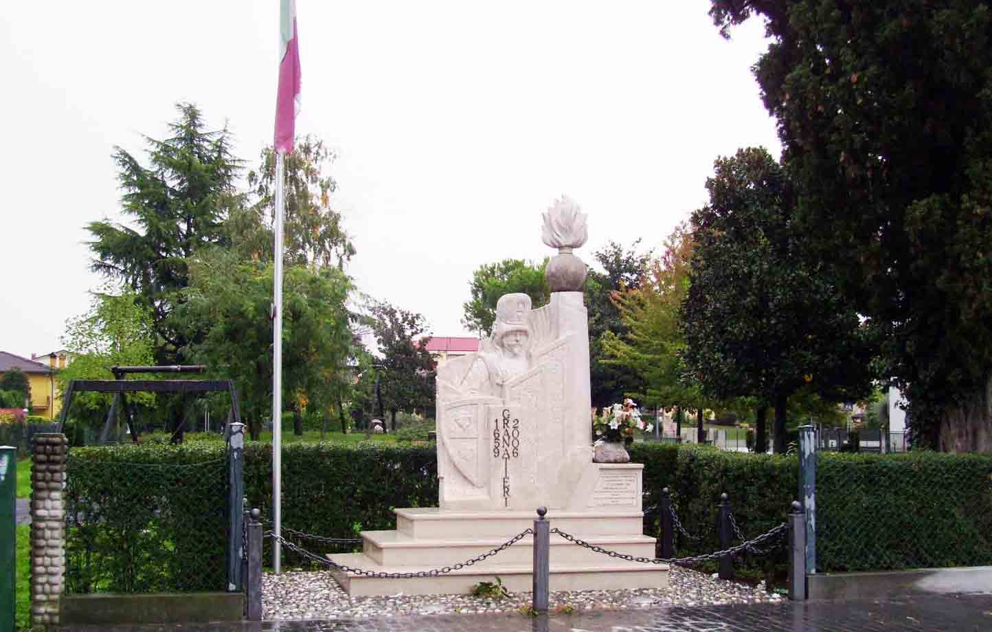 Monumento in marmo con fiamma, doge scolpito, catene, giardino con alberi sotto pioggia