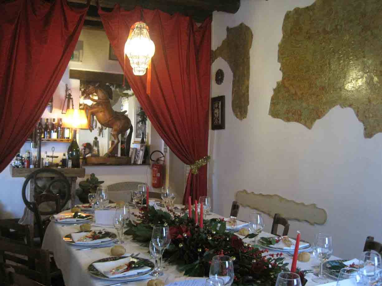 Tavola apparecchiata con candele rosse estatue di cavallo in un ristorante rustico