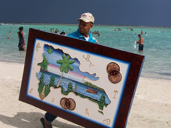 Un venditore di quadri tipici in spiaggia a Boca Chica