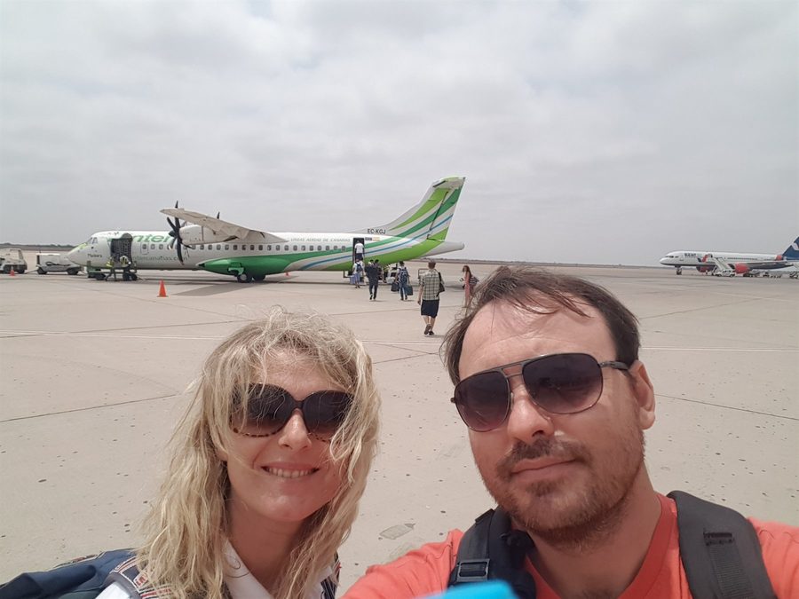 Selfie di coppia sull'asfalto dell'aeroporto di Errachidia, aereo verde fermo