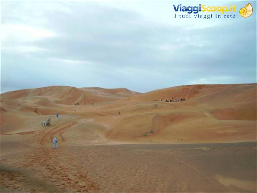 Turisti camminano sulle dune sabbiose di Erg Chebbi, Merzouga, sotto cielo nuvoloso