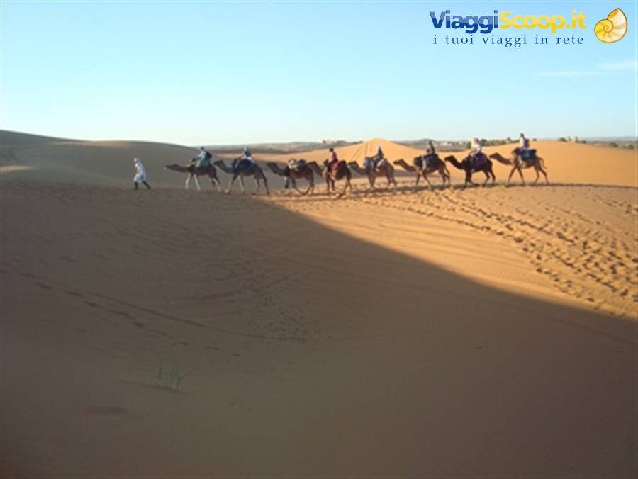 Carovana di cammelli con turisti sulle dune di sabbia della Sahara, Merzouga
