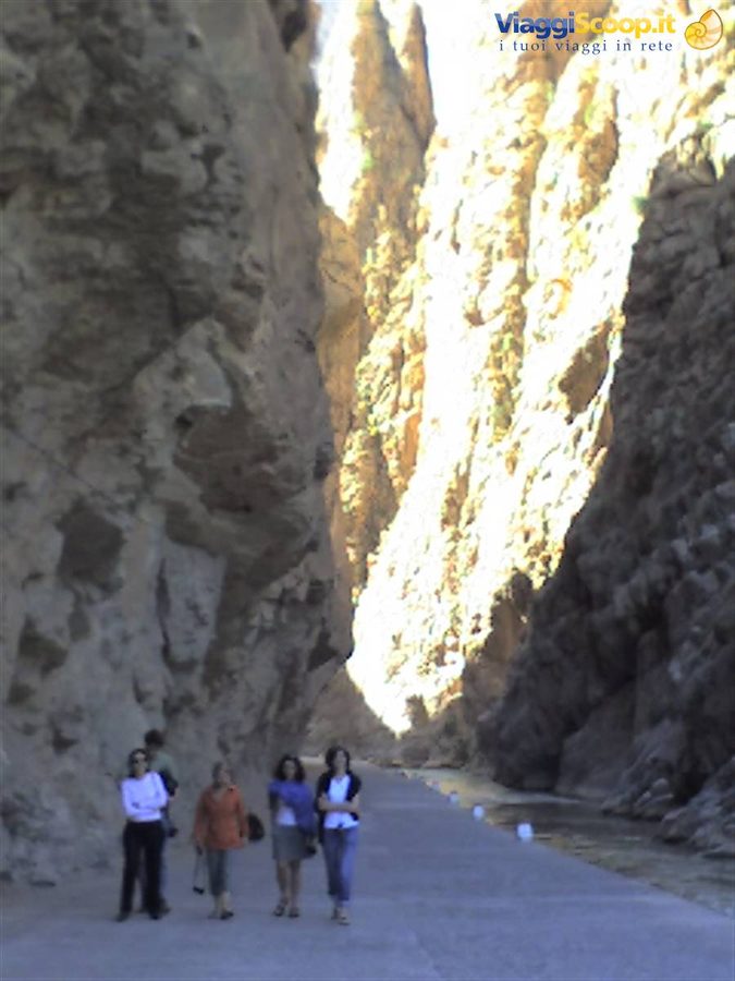 Turiste camminano sulla strada stretta tra le pareti rocciose delle Gole del Todra
