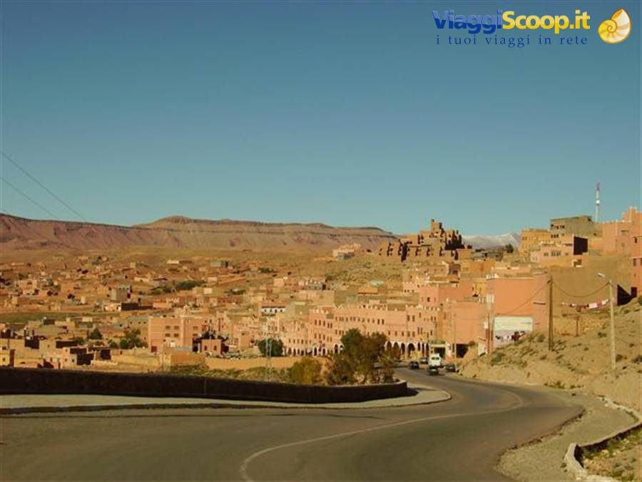 Città di Ouarzazate, case in terra rossa tra le montagne sotto cielo azzurro