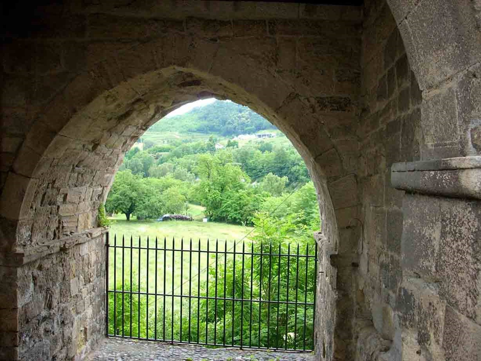 Il verde della campagna attraverso l'arco del Portino